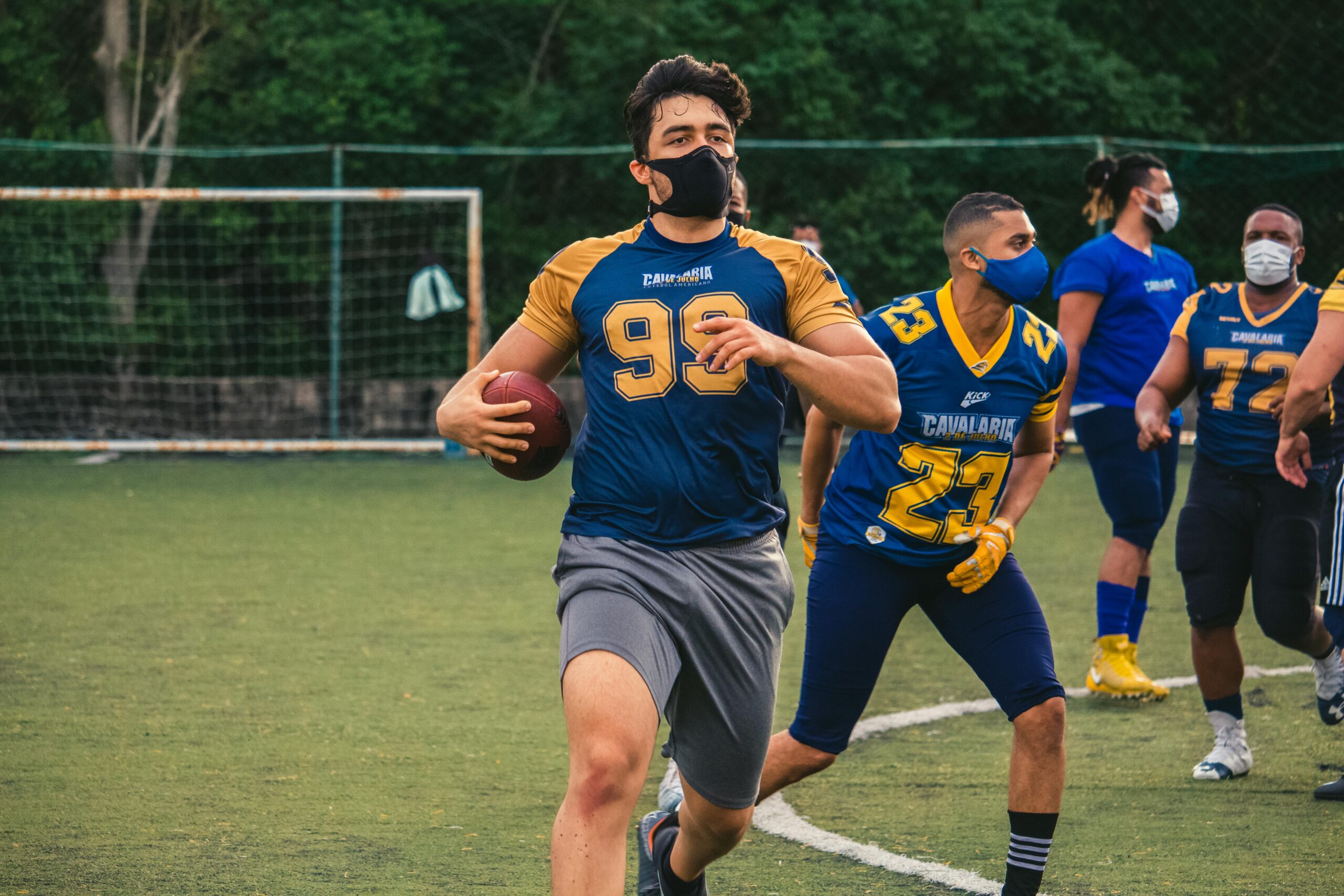 Rugby players wearing masks in action, reflecting sport in pandemic times.